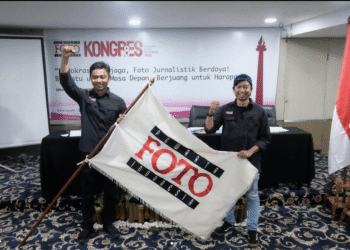 Ketua Umum PFI terpilih Dwi Pambudo dan Sekjen Galih Pradipta mengepalkan tangan sambil membentangkan bendera pataka Pewarta Foto Indonesia usai terpilih aklamasi pada Kongres VIII PFI 2025 di Jakarta.