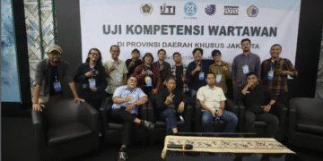 Foto bersama 11 peserta UKPFI jenjang Muda, penguji, dan panitia di depan spanduk Uji Kompetensi Wartawan di Gedung Dewan Pers, Jakarta, Desember 2025