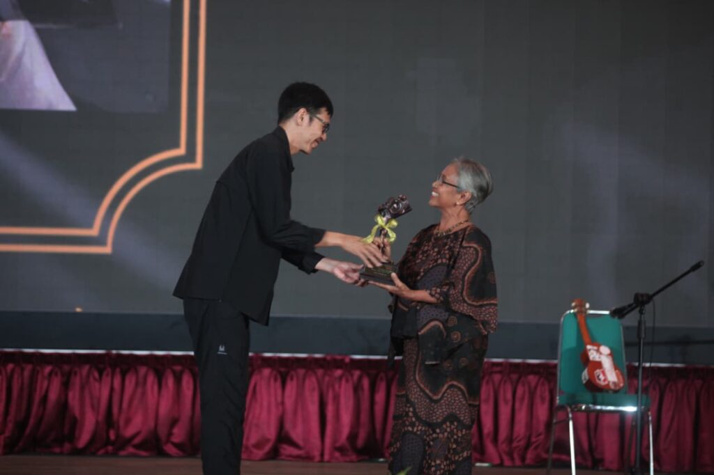 "Piagam penghargaan anumerta 'Lifetime Achievement Award' Anugerah Pewarta Foto Indonesia (APFI) Tahun 2026 berbingkai kayu, diberikan kepada 'Enny Nurhaeni' atas dedikasinya sebagai pewarta foto senior yang berintegritas semasa hidupnya. Piagam ini ditandatangani oleh Ketua Umum PFI Dwi Pambudo di Kabupaten Bogor pada 8 Mei 2026."