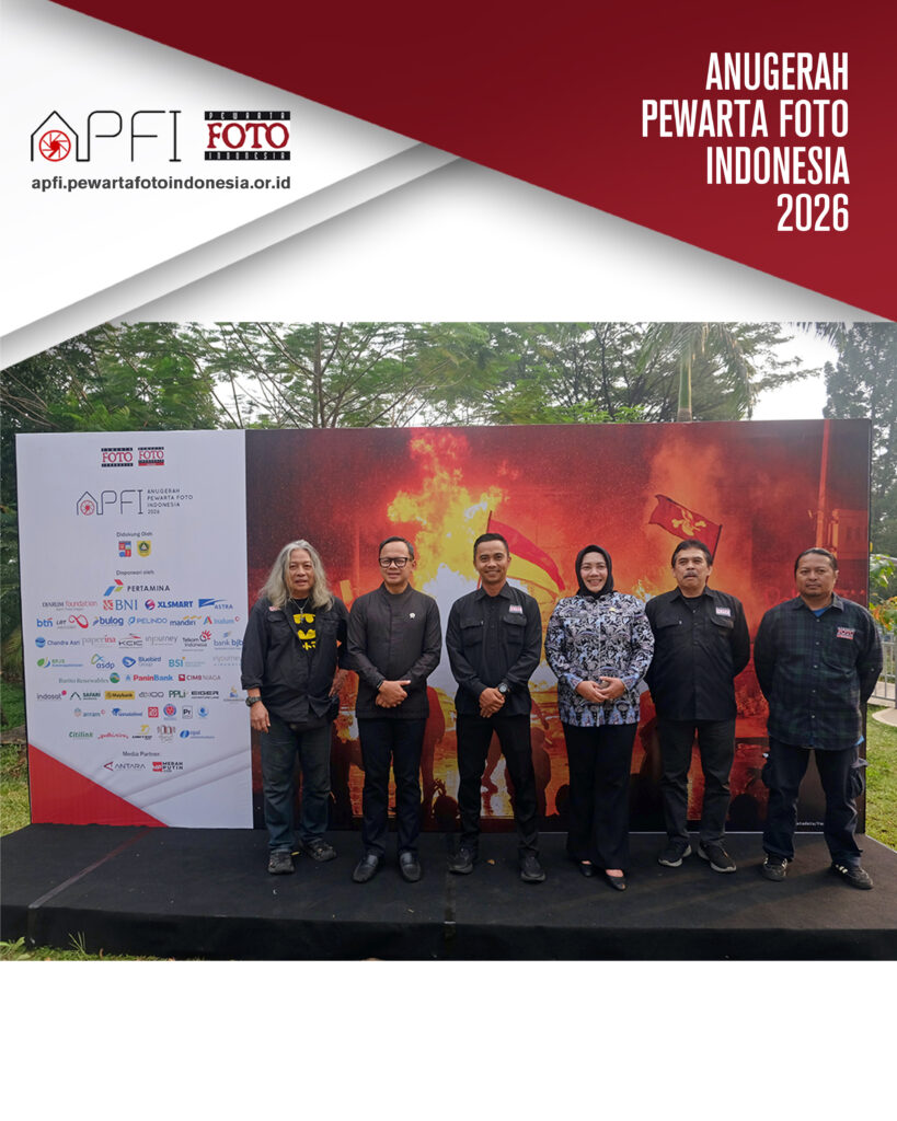 Jajaran pengurus PFI Pusat dan perwakilan juri berdiri berjejer foto bersama di depan backdrop pameran besar yang menampilkan foto unjuk rasa membara.