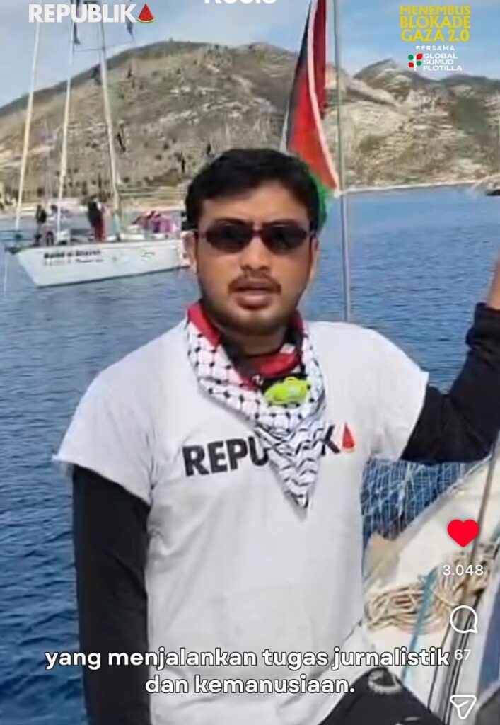 Tangkapan layar video darurat memperlihatkan Thoudy Badai, jurnalis foto Republika, mengenakan kaos putih bertuliskan "REPUBLIKA" dan syal keffiyeh di lehernya saat berada di atas dek kapal laut.