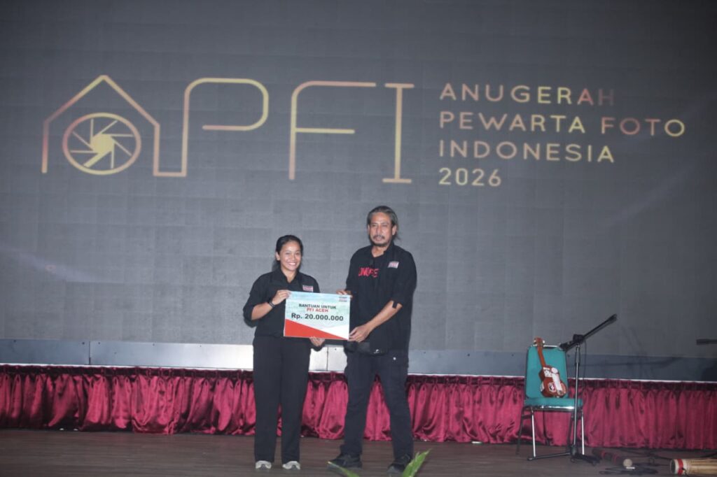 Bendahara Umum PFI Pusat Agriana Ali (kiri) menyerahkan bantuan dana secara simbolis sebesar Rp20.000.000 kepada Koordinator Wilayah Barat PFI Hendra Syamhari untuk program air bersih di Aceh pada acara APFI 2026.