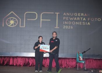 Bendahara Umum PFI Pusat Agriana Ali (kiri) menyerahkan bantuan dana secara simbolis sebesar Rp20.000.000 kepada Koordinator Wilayah Barat PFI Hendra Syamhari untuk program air bersih di Aceh pada acara APFI 2026.