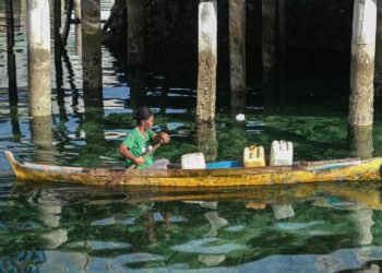 Seorang ibu rumah tangga mencari air bersih menggunakan perahu di Desa Bajo Mola, Wakatobi, Sulawesi Tenggara.