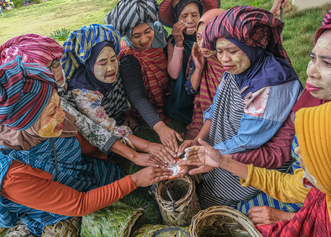 Sejumlah ibu rumah tangga mengambil bedak basah dengan telapak tangan sebelum mengikuti tradisi Hekente di Wakatobi, Sulawesi Tenggara